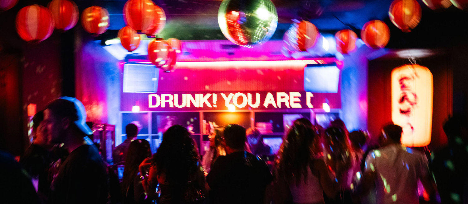 Crowd enjoying a lively concert or nightclub event with colorful lights and hanging lanterns 