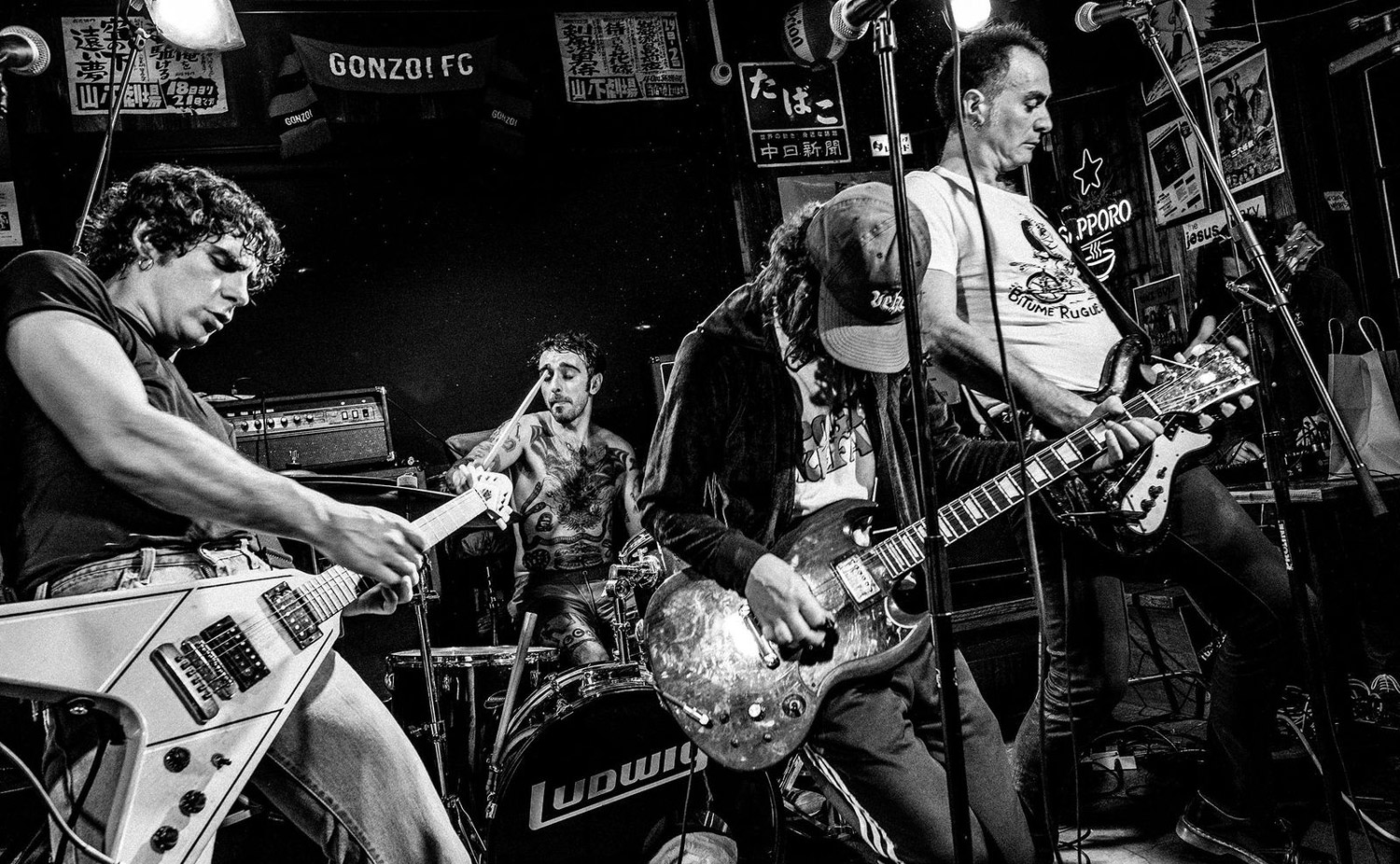 Black-and-white photo of a live rock band performing on stage